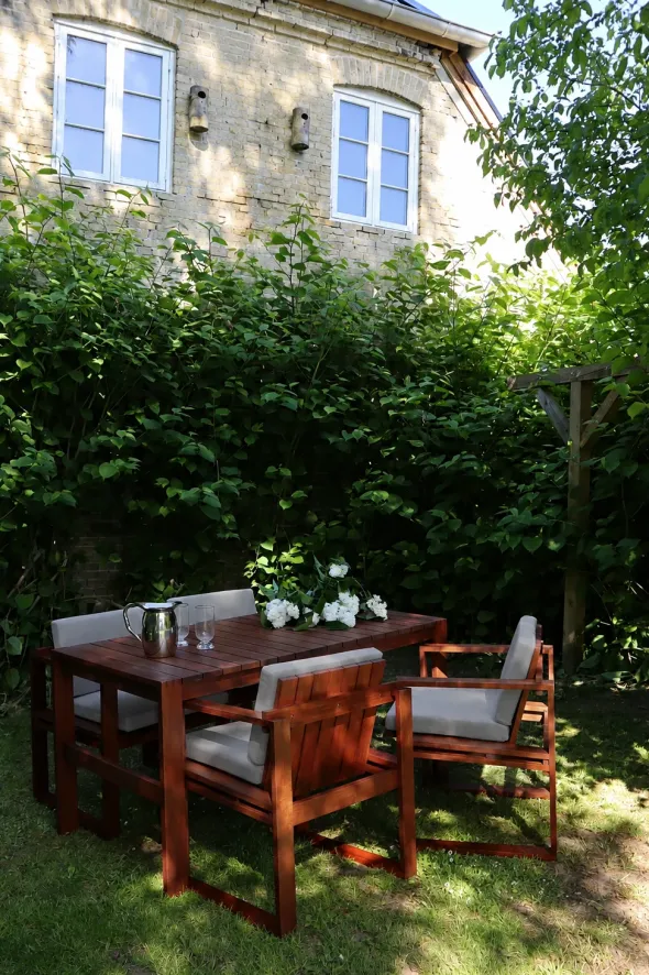 Bodil Kjær havemøbelsæt i olieret teak med 1 havebord og 4 havestole inkl. hynder fra Carl Hansen & Søn